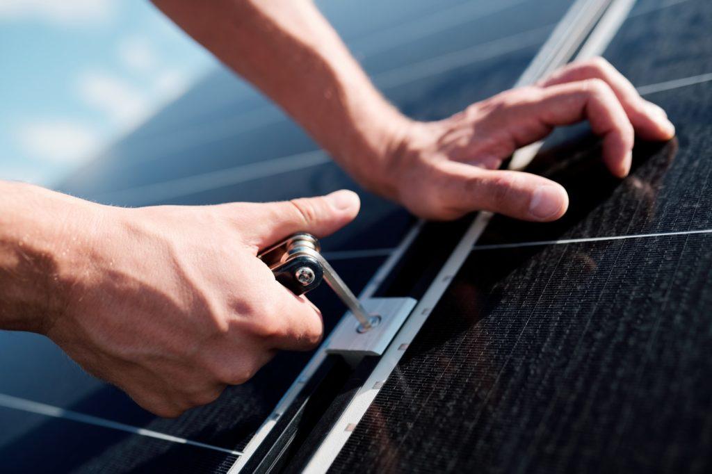 Hands of professional technician or engineer installing solar panels